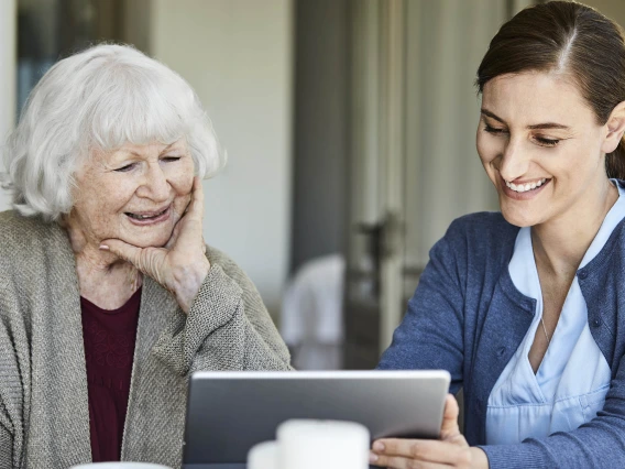 Older and younger woman look at tablet
